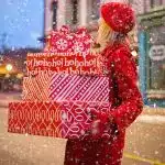 Woman with a stack of Christmas presents she has bought and wrapped