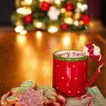 pic of a mug of hot chocolate, a tree and sweets - create a cosy atmosphere on Christmas Day