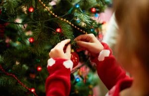 Young girl adding trimming as part of the Christmas decoration tips