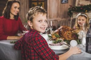Young family on Christmas Day tucking into a juicy turkey