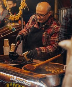 A stallholder at Bath Christmas market preparing mulled wine