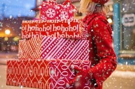 Woman with a stack of Christmas presents she has bought and wrapped