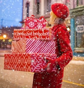 Woman with a stack of Christmas presents she has bought and wrapped