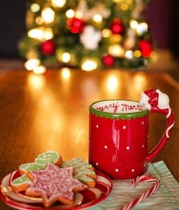 pic of a mug of hot chocolate, a tree and sweets - create a cosy atmosphere on Christmas Day