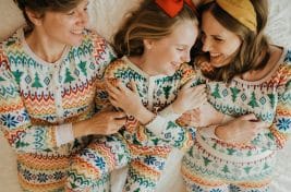 Pic of three generation in festive matching pyjamas to illustrate an article about Christmas pyjamas