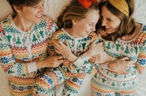 Pic of three generation in festive matching pyjamas to illustrate an article about Christmas pyjamas