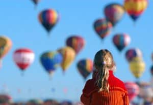 Pic of a child looking at hot air balloons to illustrate a story about unusual Xmas gifts - hot air air balloon rides as a Christmas present