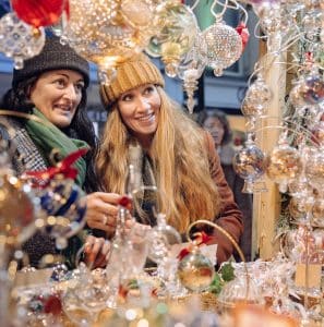 Friends enjoy a colourful stall at Bath Christmas market 
