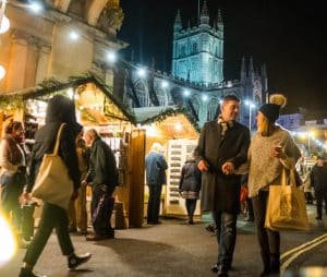 A man and woman strolling at Bath Christmas market has so much to see in wonderful surroundings