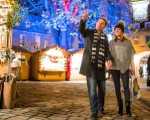 A couple stroll the lovely festive streets of Bath Christmas market